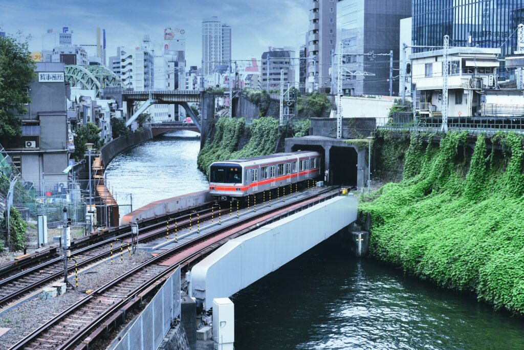 Red and white Tokyo Marunouchi Line train running on elevated tracks through the city