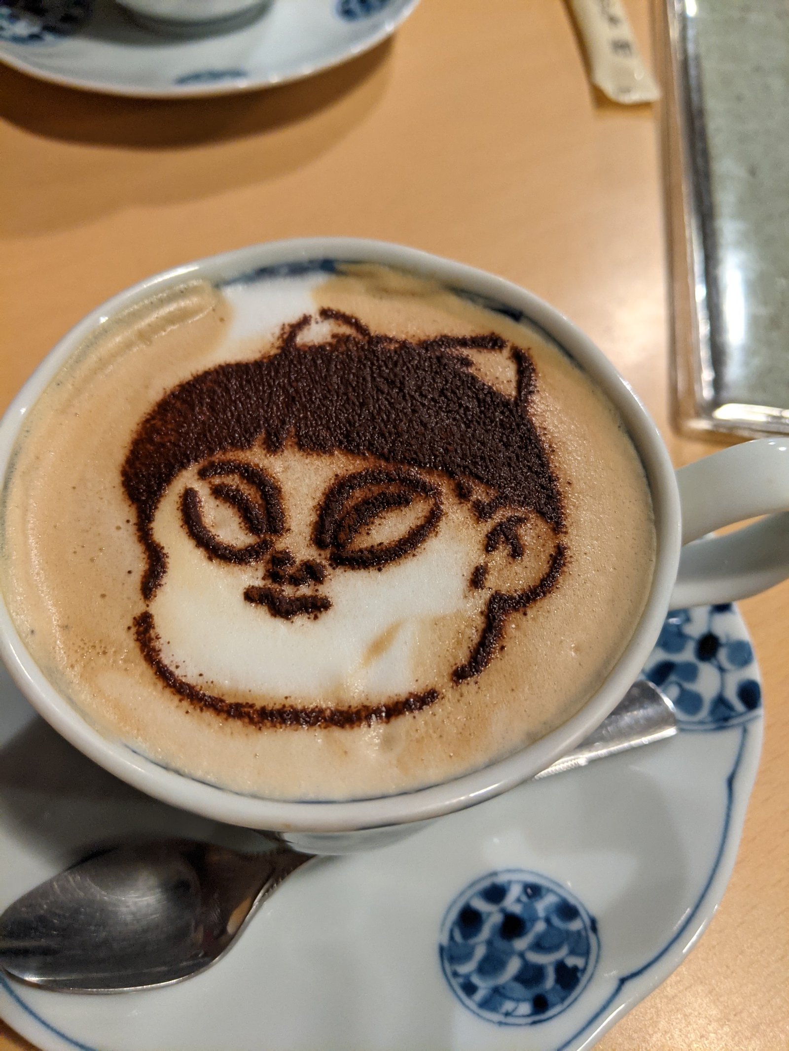 A cute character drawn in latte art at a family-friendly Tokyo cafe.