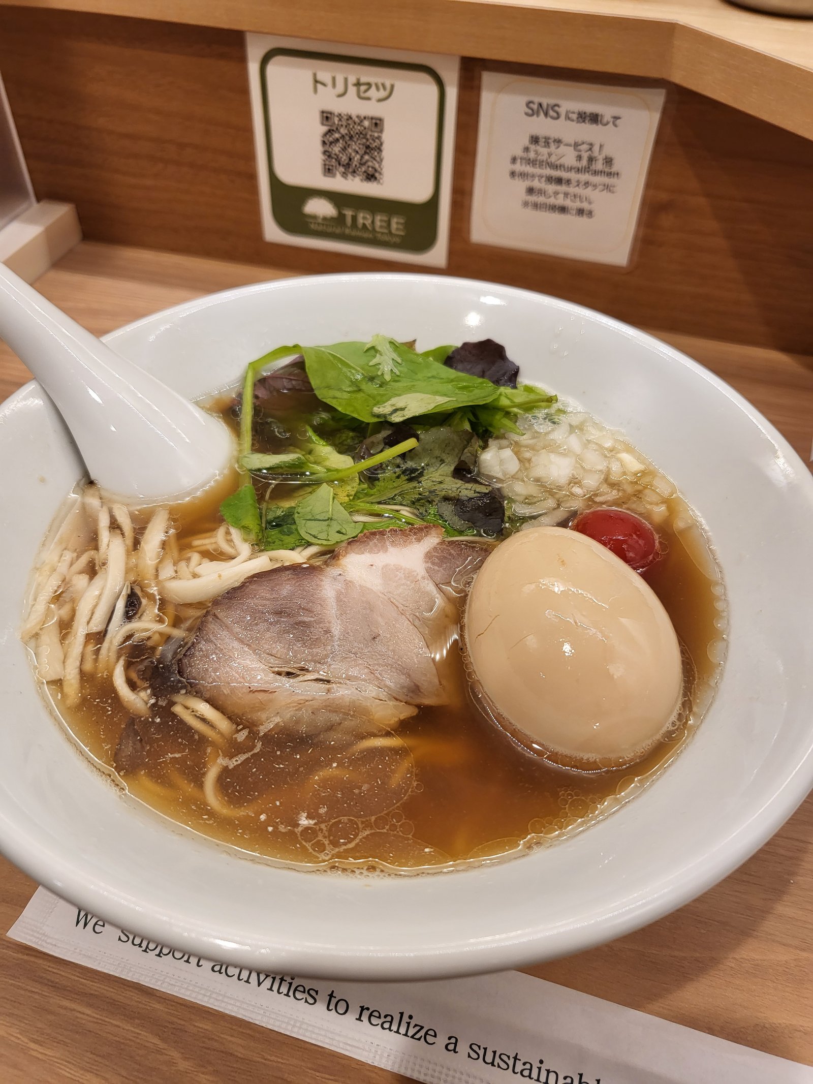 A bowl of shoyu ramen with chashu pork and a seasoned soft-boiled egg.