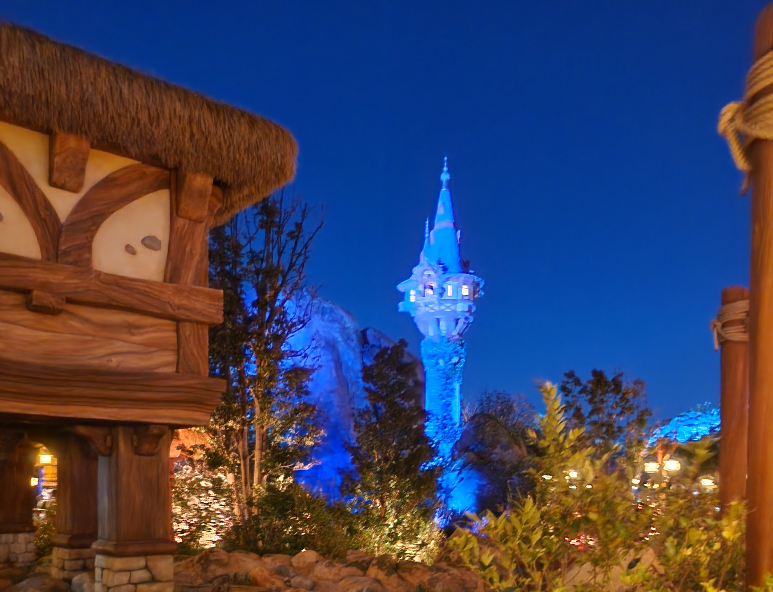 Rapunzel tower lit up blue at night in the Fantasy Springs area of Tokyo DisneySea.