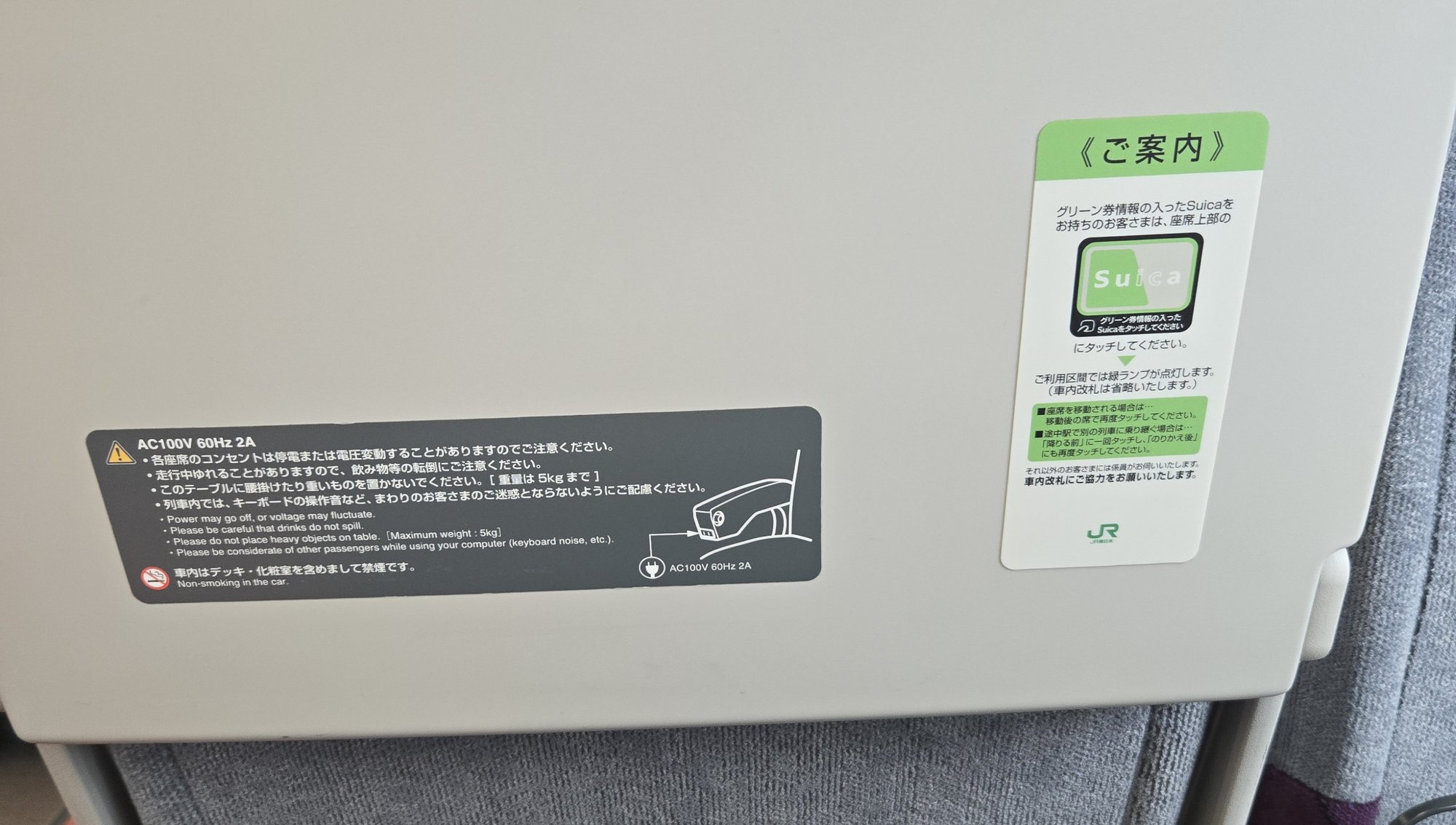Suica touch panel information card and AC100V outlet on the back of a JR Green Car seat.