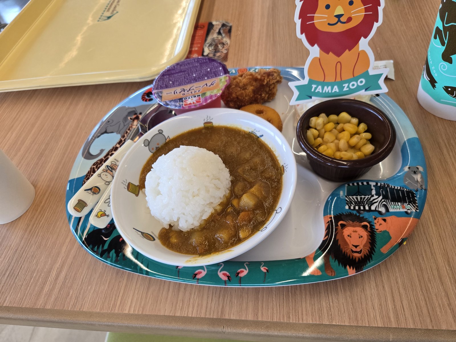 A children's curry rice set on a Tama Zoo character tray, with corn and fried chicken.