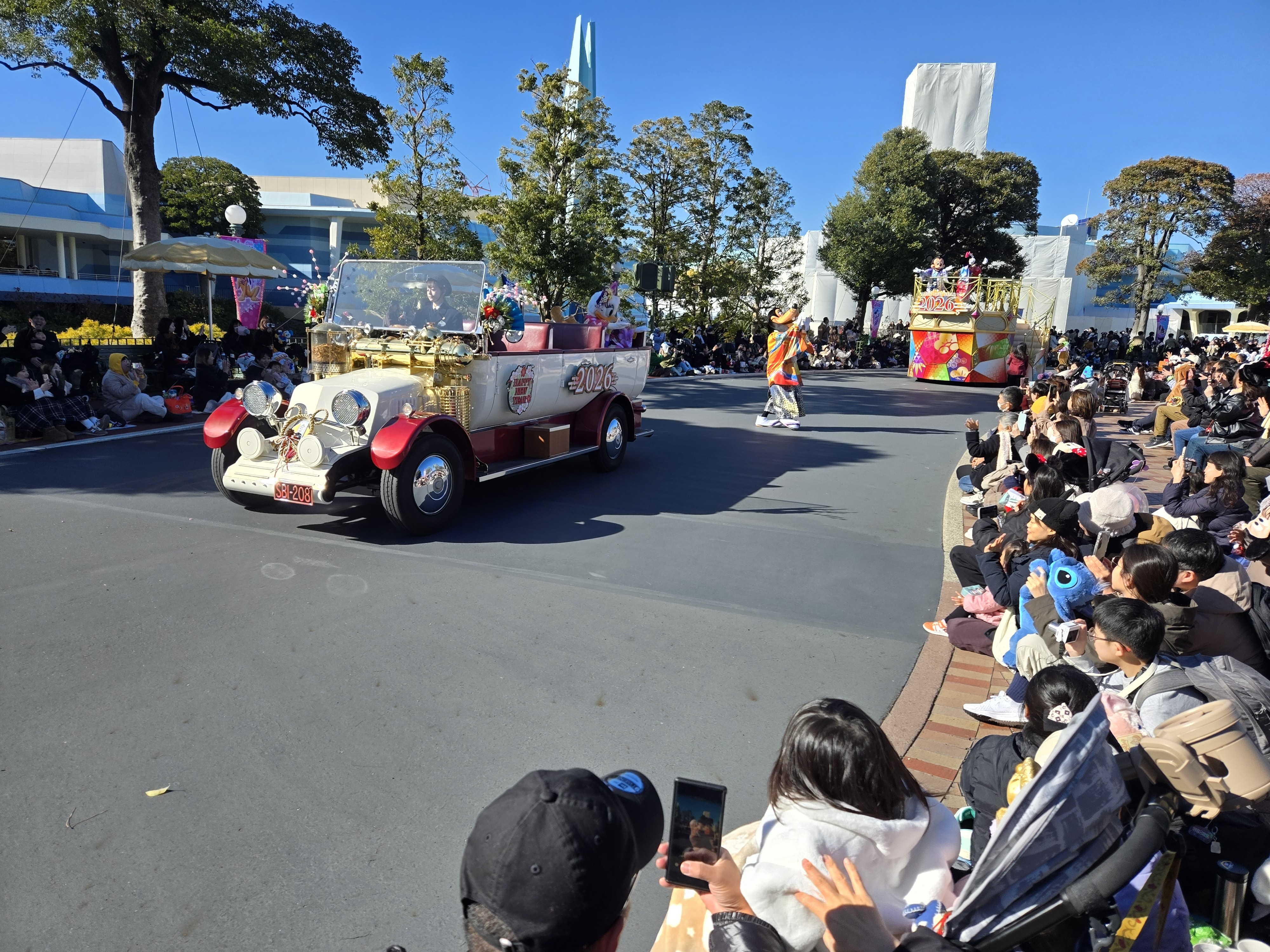 A vintage-style parade car marked 2026 driving through Tokyo Disneyland during a New Year parade.